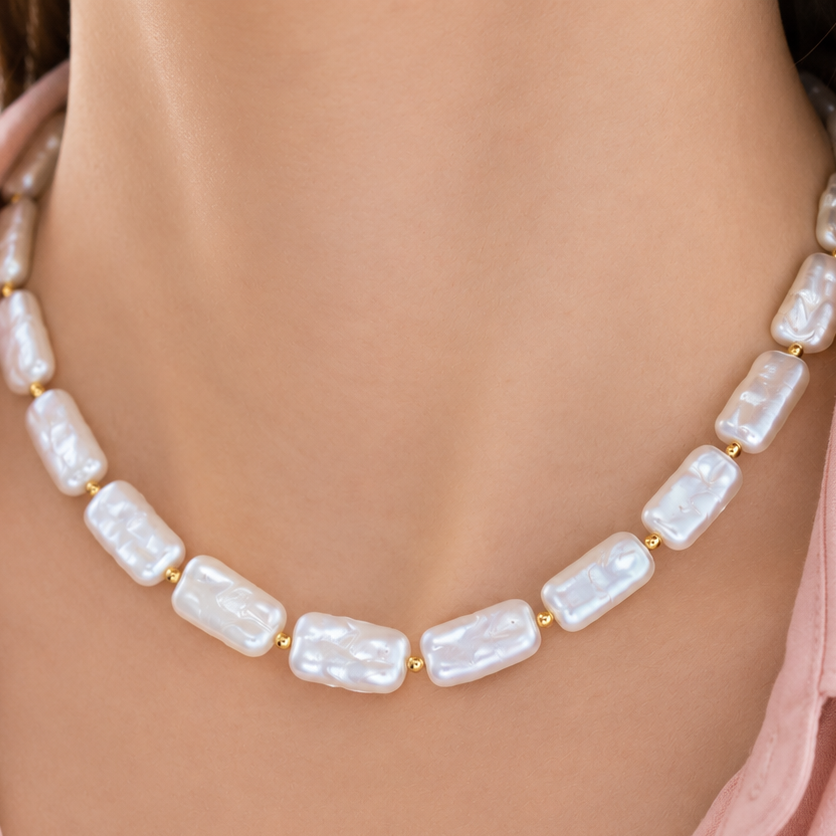 Collier Eiréné avec perles blanches nacrées et détails dorés.