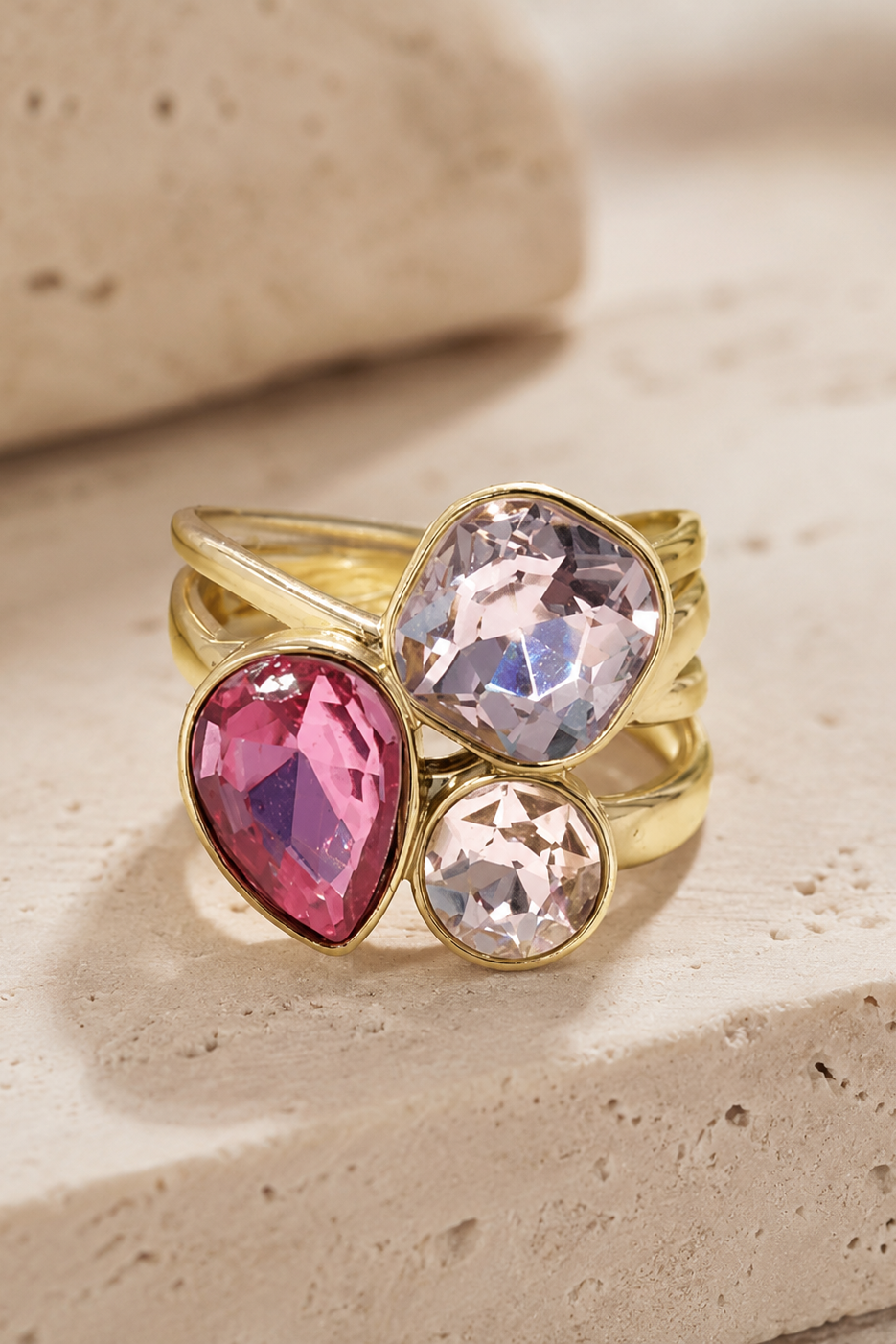 Bague dorée Iris avec pierres roses et transparentes facettées.