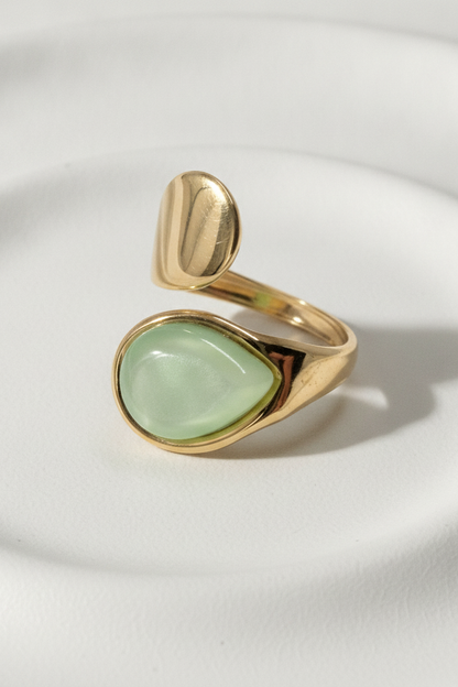 Bague dorée Émera avec pierre verte effet nacré et design ouvert.