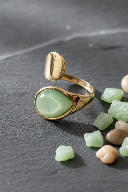 Bague dorée Émera avec pierre verte effet nacré et design ouvert.