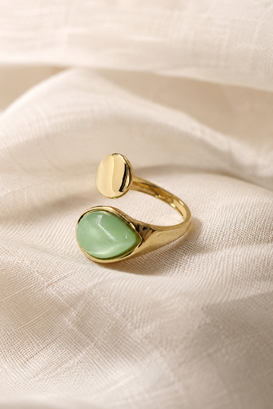 Bague dorée Émera avec pierre verte effet nacré et design ouvert.