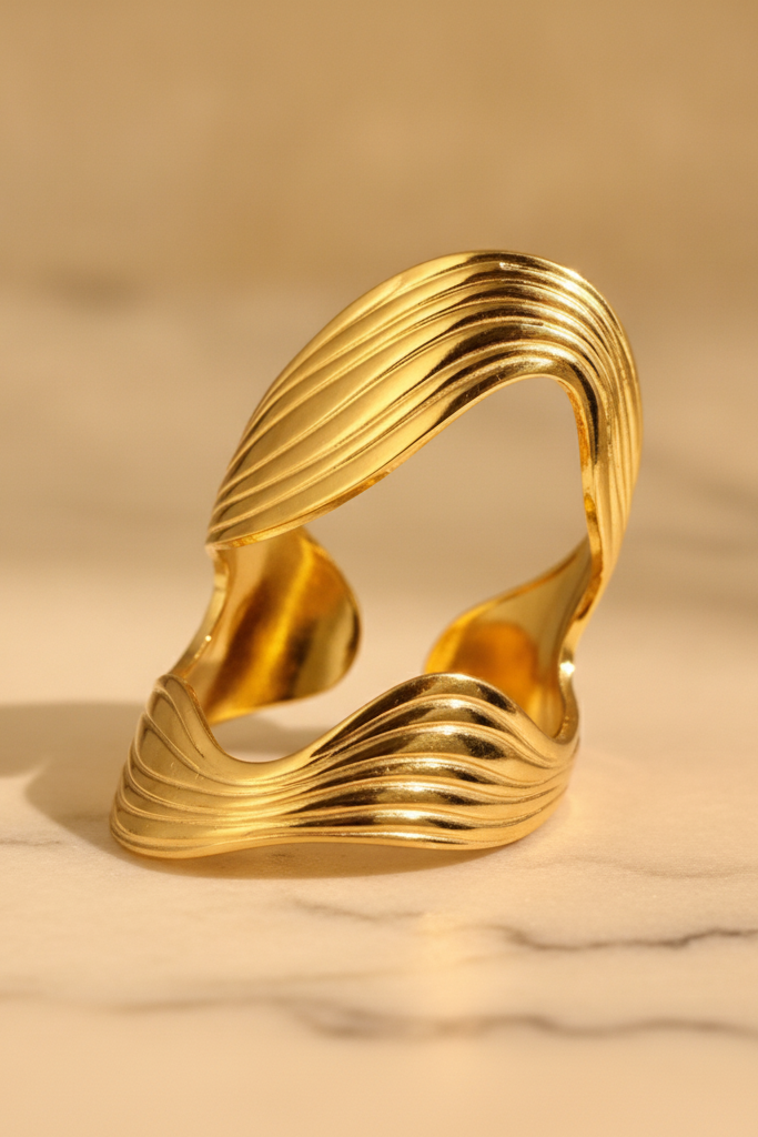 Bague dorée ondulée Ondine avec design ouvert et lignes sculptées.