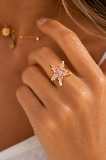 Bague étoile de mer Thétis dorée avec détails nacrés et reflets marbrés inspirés de l’océan.