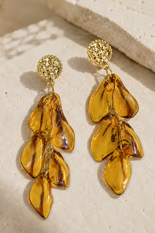 Boucles d'oreilles Éos Hatoria en acier inoxydable doré avec pétales ambrés translucides.