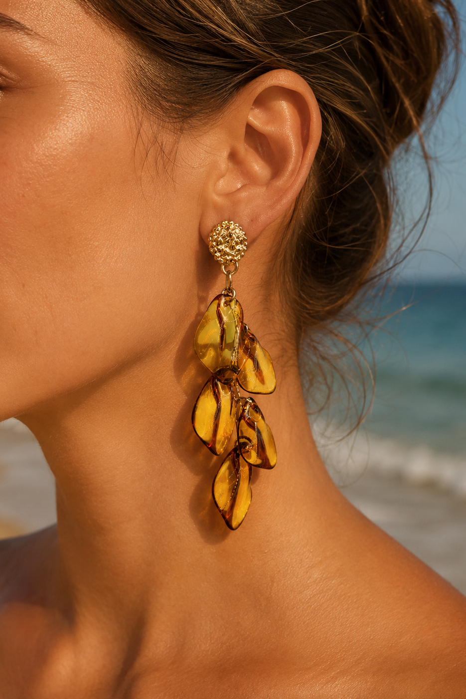 Boucles d'oreilles Éos Hatoria en acier inoxydable doré avec pétales ambrés translucides.