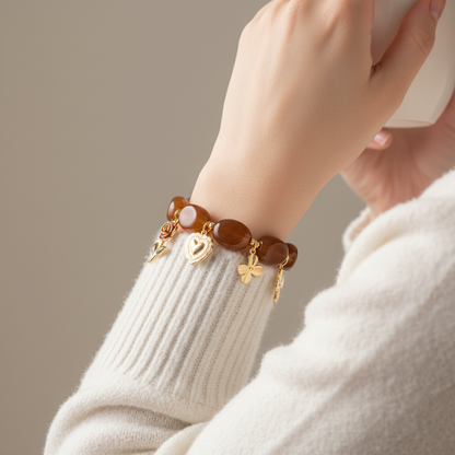 Bracelet Perséphone doré avec pierres marron et breloques décoratives.