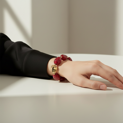 Bracelet Vesta avec pierres rouges marbrées et détails dorés.