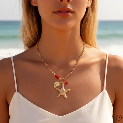 Collier Galatée doré avec pendentif étoile de mer et détails rouges porté au cou.